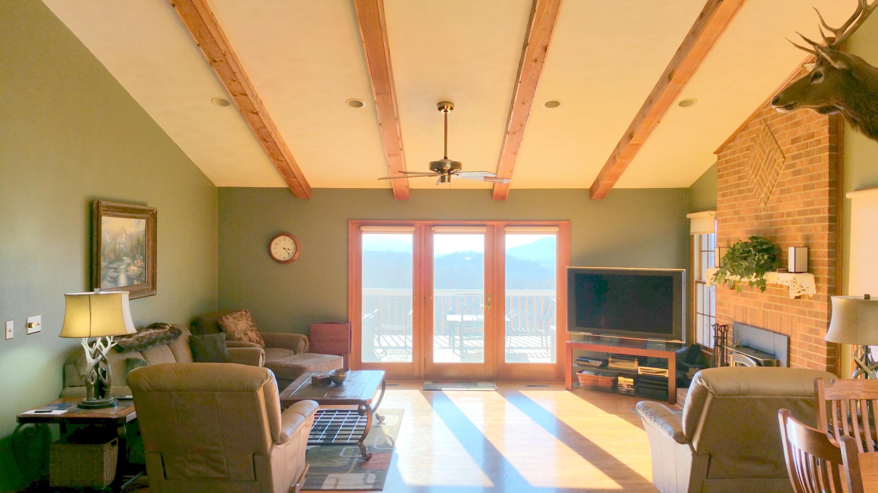 1354 Archway Road Blue Ridge, VA 24064 - Photo 6 of 22 a living room with furniture a flat screen tv and a floor to ceiling window