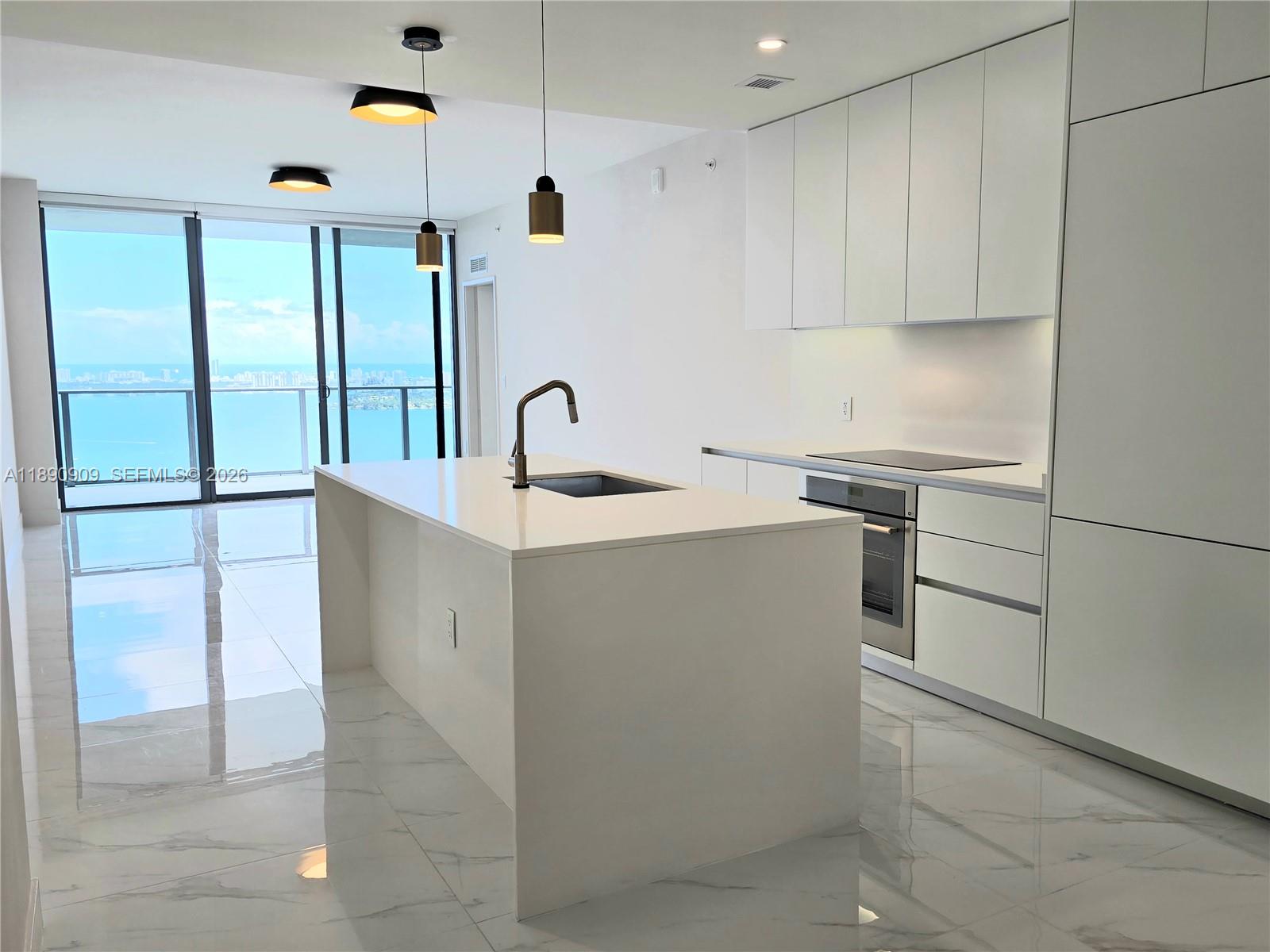 700 Northeast 24th Street, Unit 4004 Miami, FL 33137 - Photo 12 of 68 a kitchen with a sink cabinets and appliances