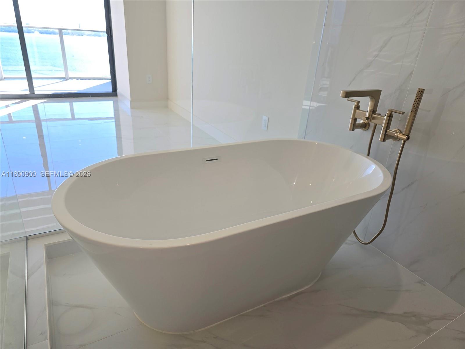 700 Northeast 24th Street, Unit 4004 Miami, FL 33137 - Photo 34 of 68 a white bath tub sitting in a bathroom
