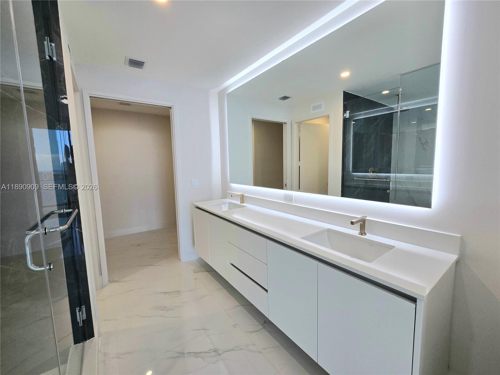 700 Northeast 24th Street, Unit 4004 Miami, FL 33137 - Photo 35 of 68 a bathroom with a double vanity sink a and mirror
