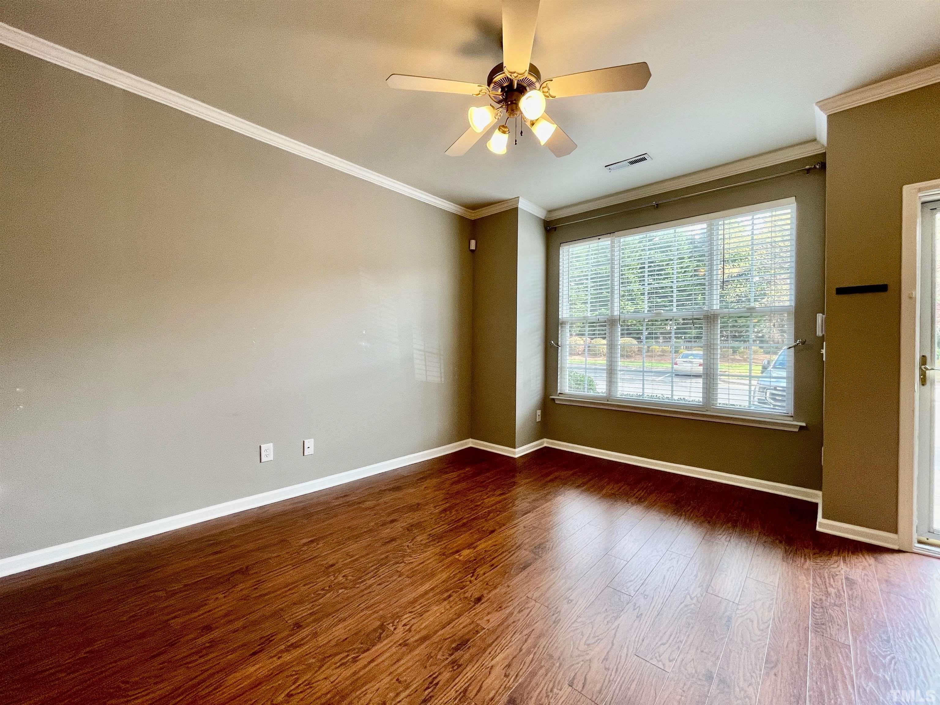 8467 Reedy Ridge Lane Raleigh, NC 27613 - Photo 11 of 46 an empty room with wooden floor and windows