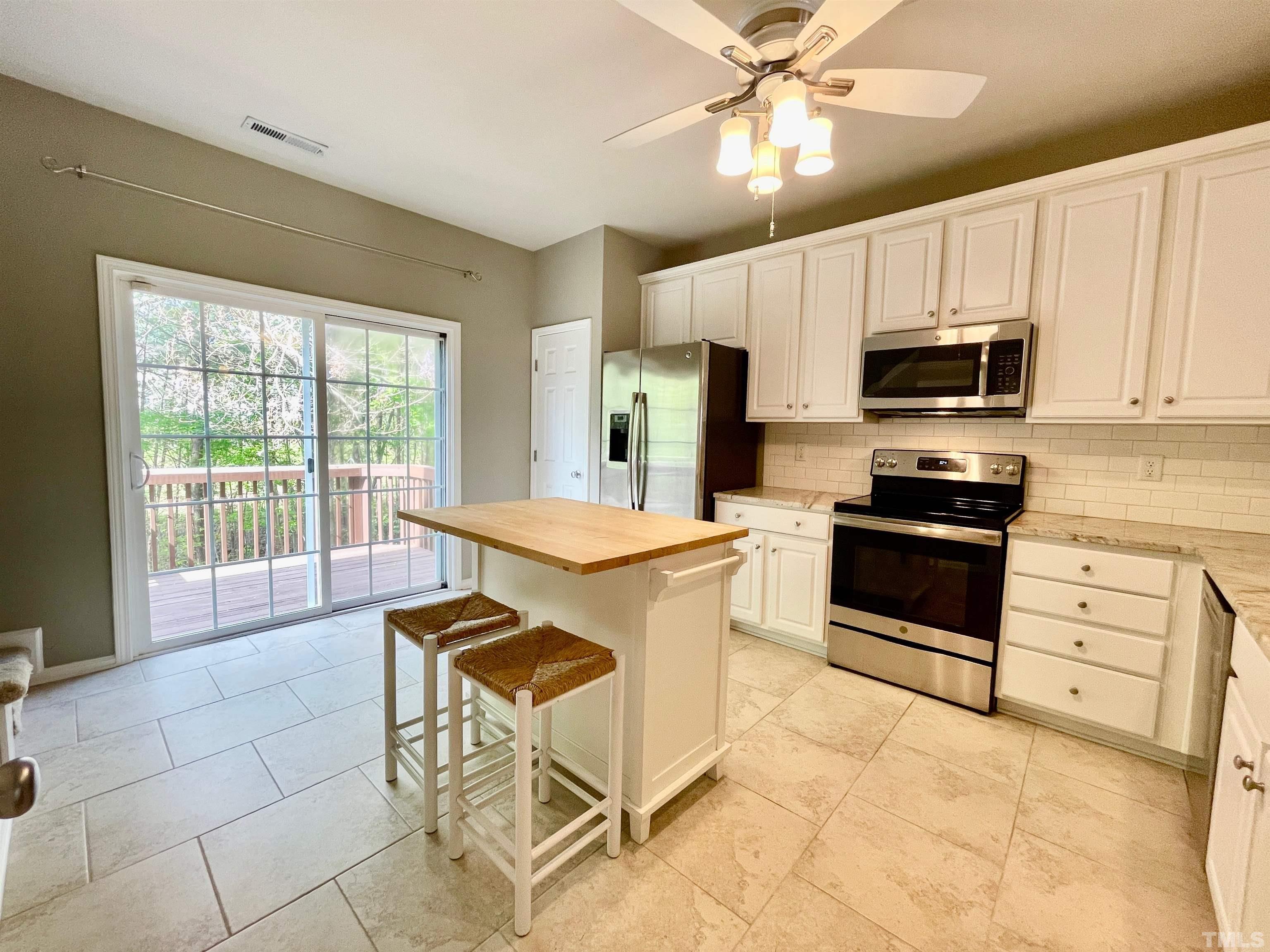 8467 Reedy Ridge Lane Raleigh, NC 27613 - Photo 14 of 46 a kitchen with granite countertop a stove cabinets and stainless steel appliances