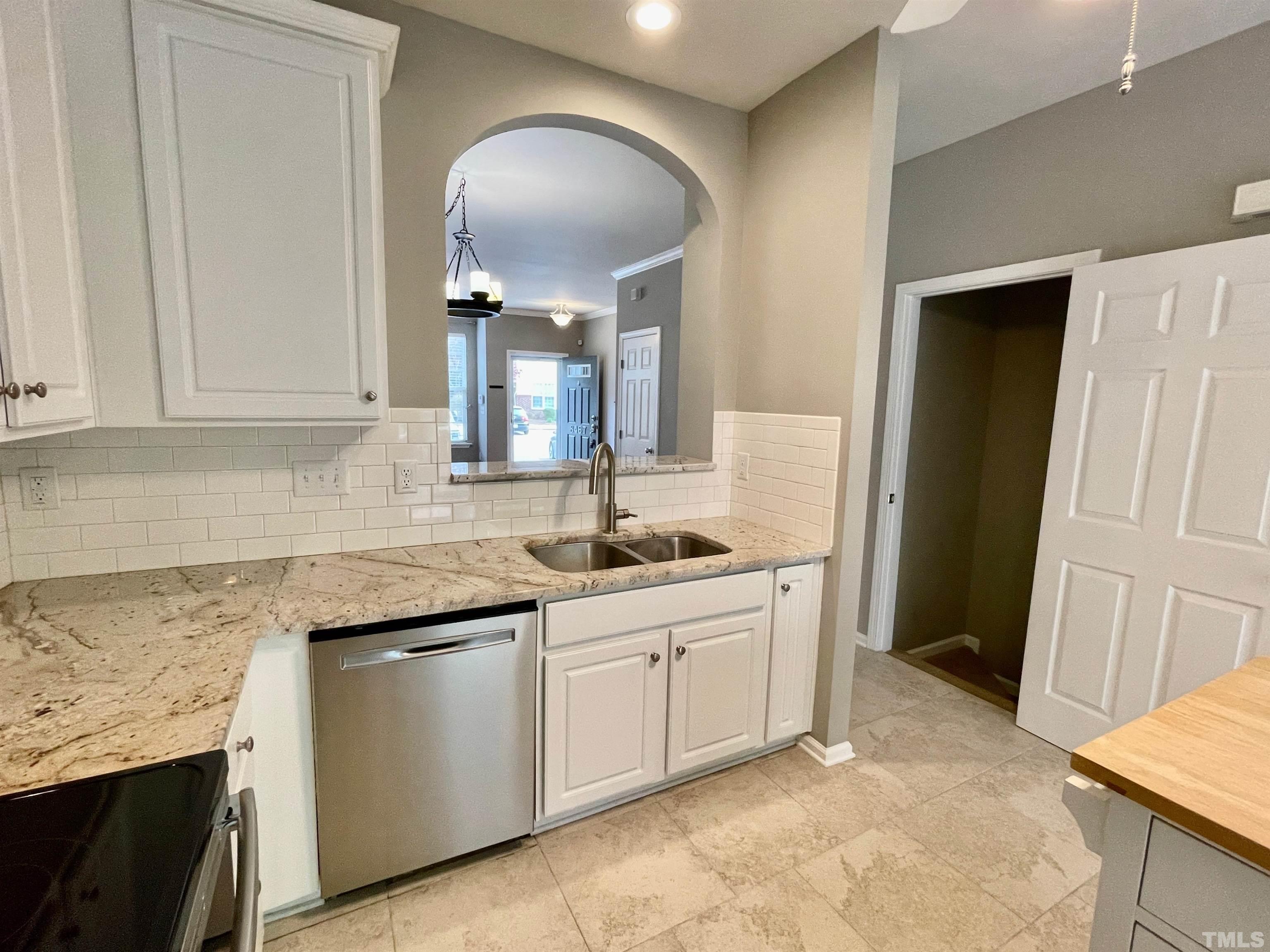 8467 Reedy Ridge Lane Raleigh, NC 27613 - Photo 18 of 46 a kitchen with granite countertop a sink stainless steel appliances and cabinets