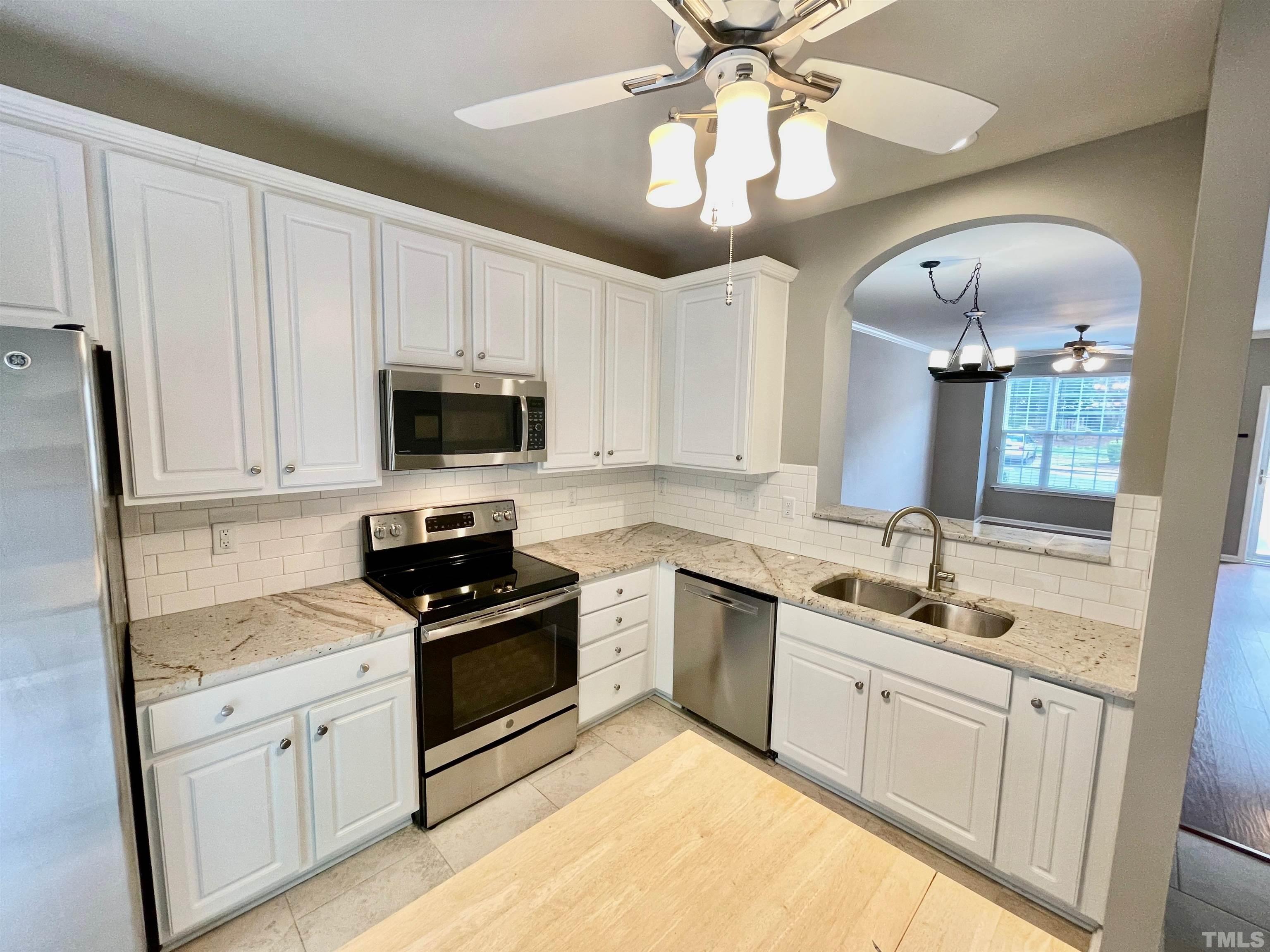 8467 Reedy Ridge Lane Raleigh, NC 27613 - Photo 19 of 46 a kitchen with a sink stove and microwave
