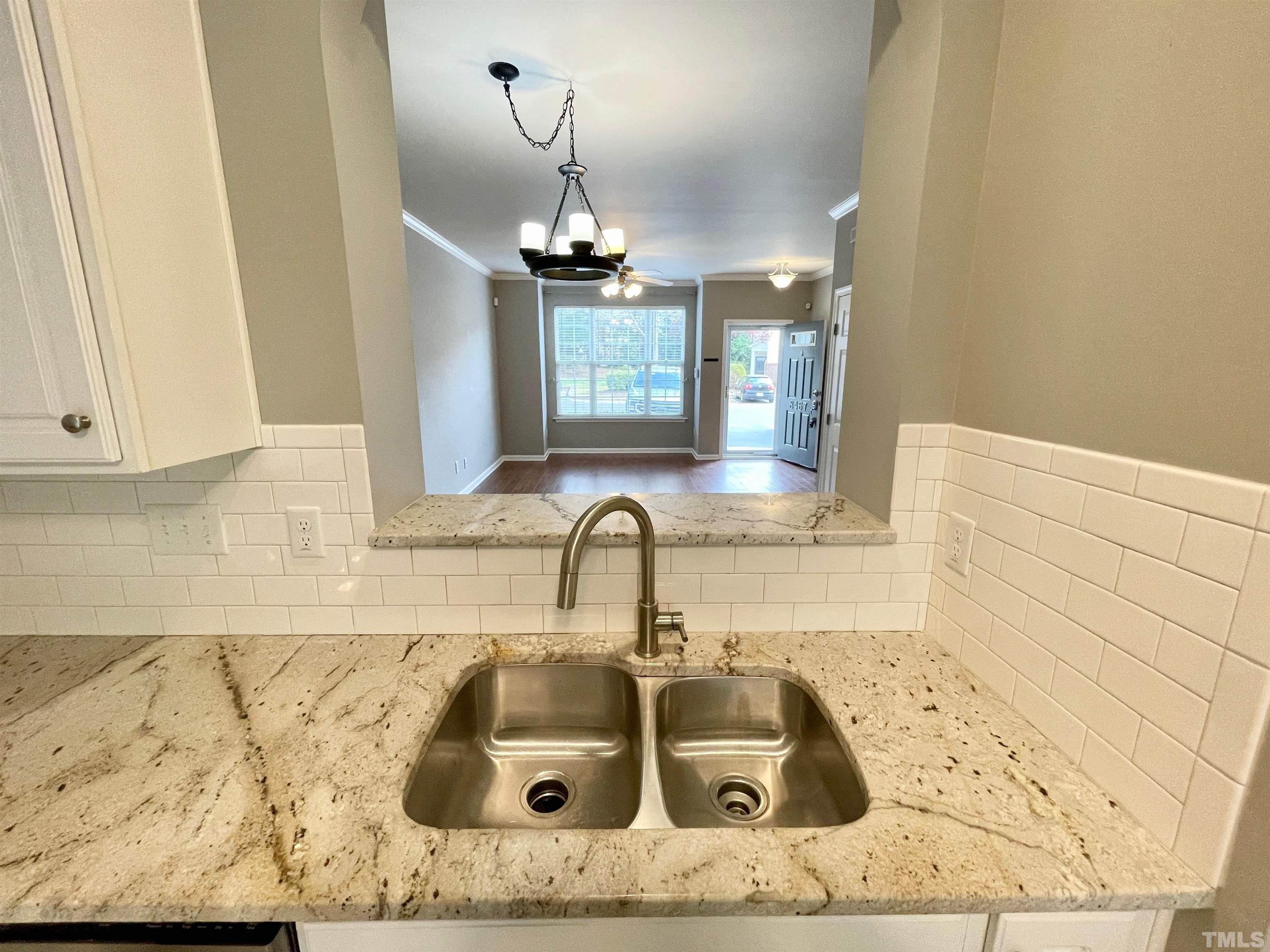 8467 Reedy Ridge Lane Raleigh, NC 27613 - Photo 22 of 46 a kitchen with a sink and chandelier