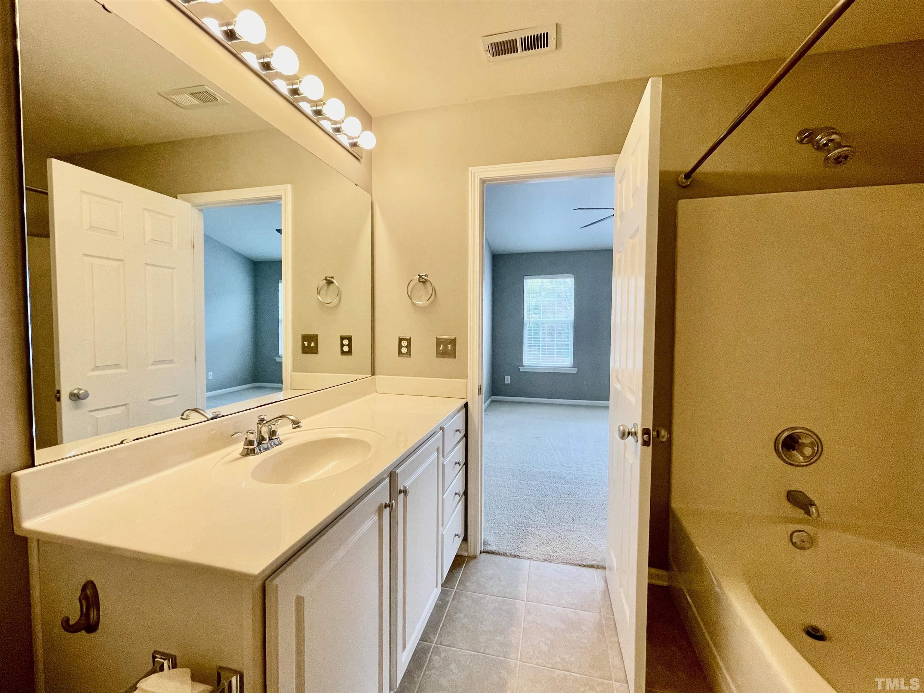 8467 Reedy Ridge Lane Raleigh, NC 27613 - Photo 33 of 46 a bathroom with a tub sink and mirror