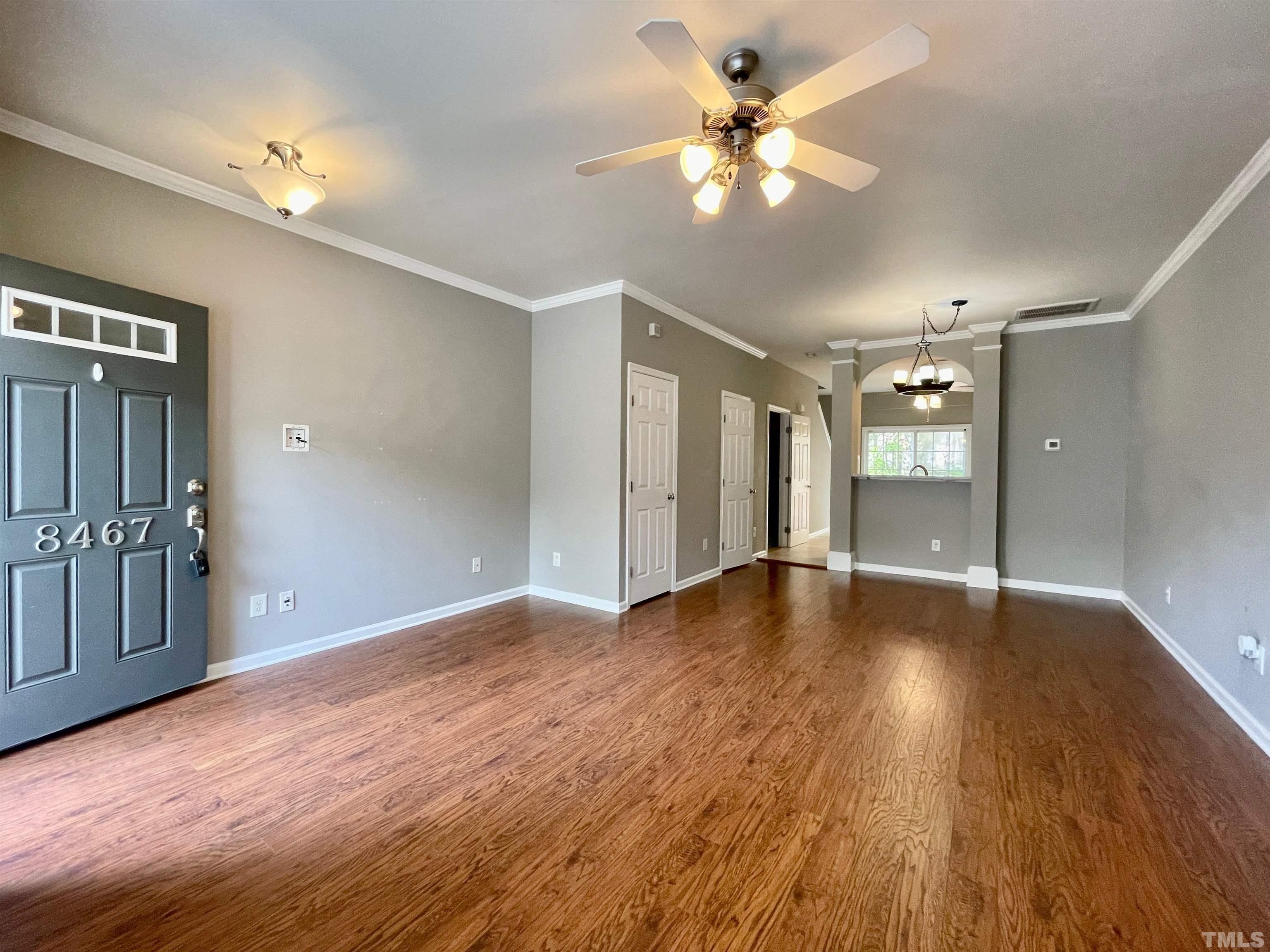8467 Reedy Ridge Lane Raleigh, NC 27613 - Photo 5 of 46 a view of an empty room with wooden floor and a ceiling fan