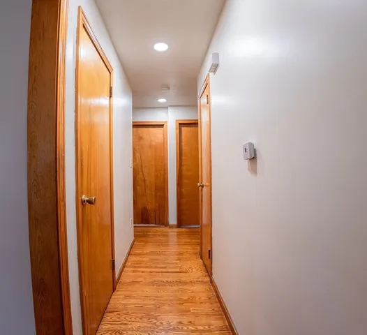 a view of a hallway with wooden floor and staircase