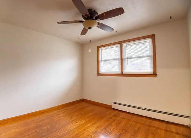 an empty room with a window and a ceiling fan