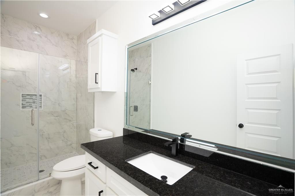 1408 South Xanthia Street, Unit 1 Alton, TX 78573 - Photo 7 of 19 a bathroom with a granite countertop sink toilet and shower