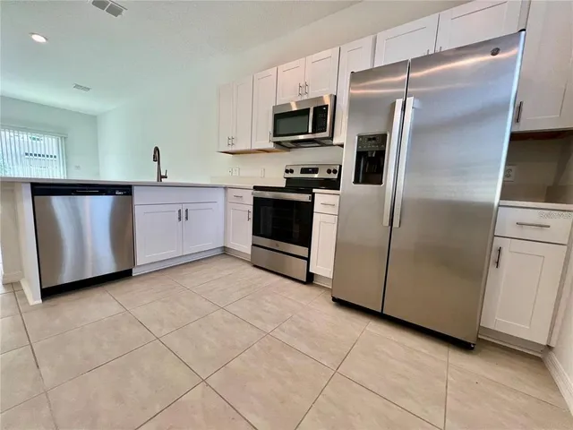 a kitchen with stainless steel appliances a refrigerator sink and microwave
