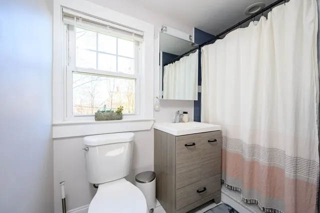 a bathroom with a sink a toilet and a window