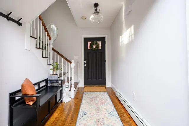 a view of a hallway with wooden floor and staircase