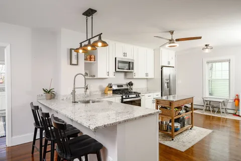 a kitchen with sink cabinets and wooden floor