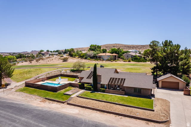1470 Redwood Tree Street St. George, UT 84790 - Photo 40 of 53 Expansive property featuring a rectangular pool with surrounding brick wall, a detached garage with a concrete driveway, and a covered patio