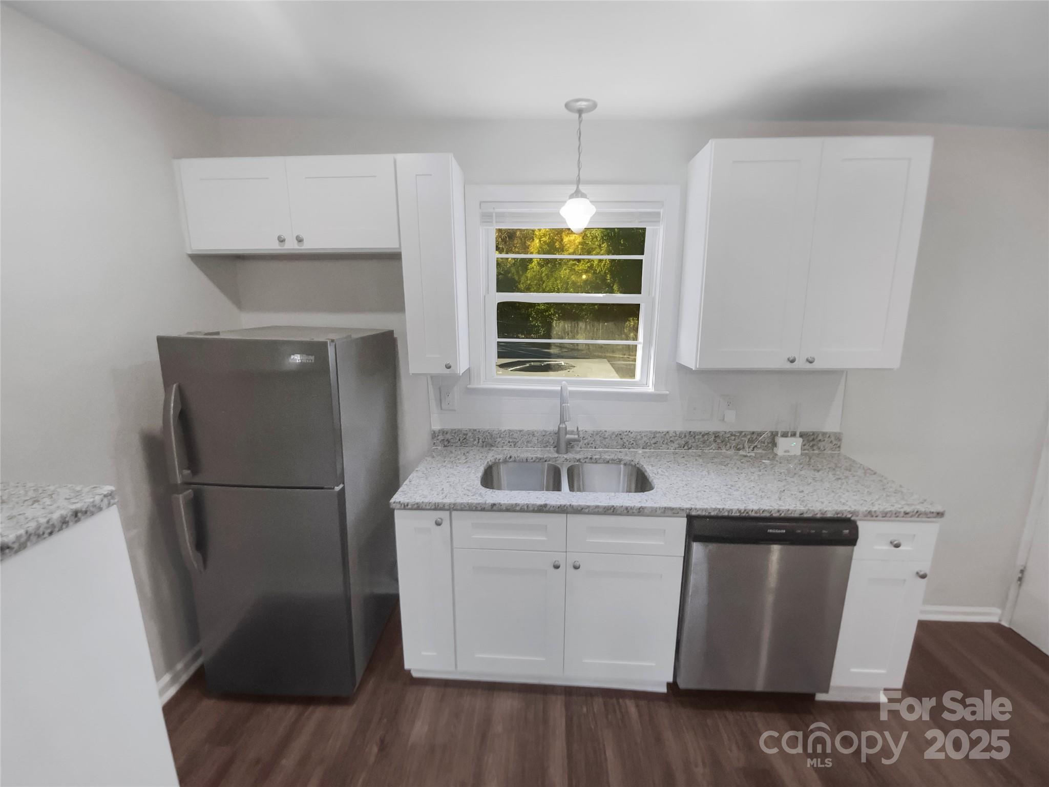 349 Wakefield Drive, Unit A Charlotte, NC 28209 - Photo 12 of 20 a kitchen with a sink a refrigerator a window and cabinets