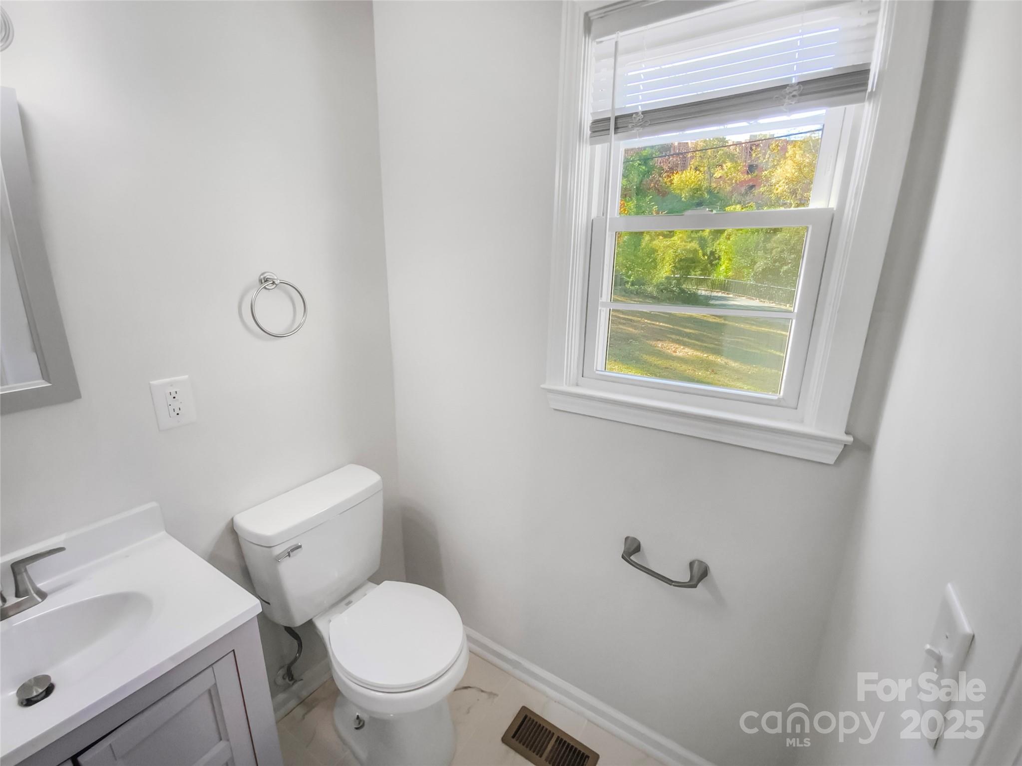 349 Wakefield Drive, Unit A Charlotte, NC 28209 - Photo 15 of 20 a white toilet sitting next to a bathroom sink