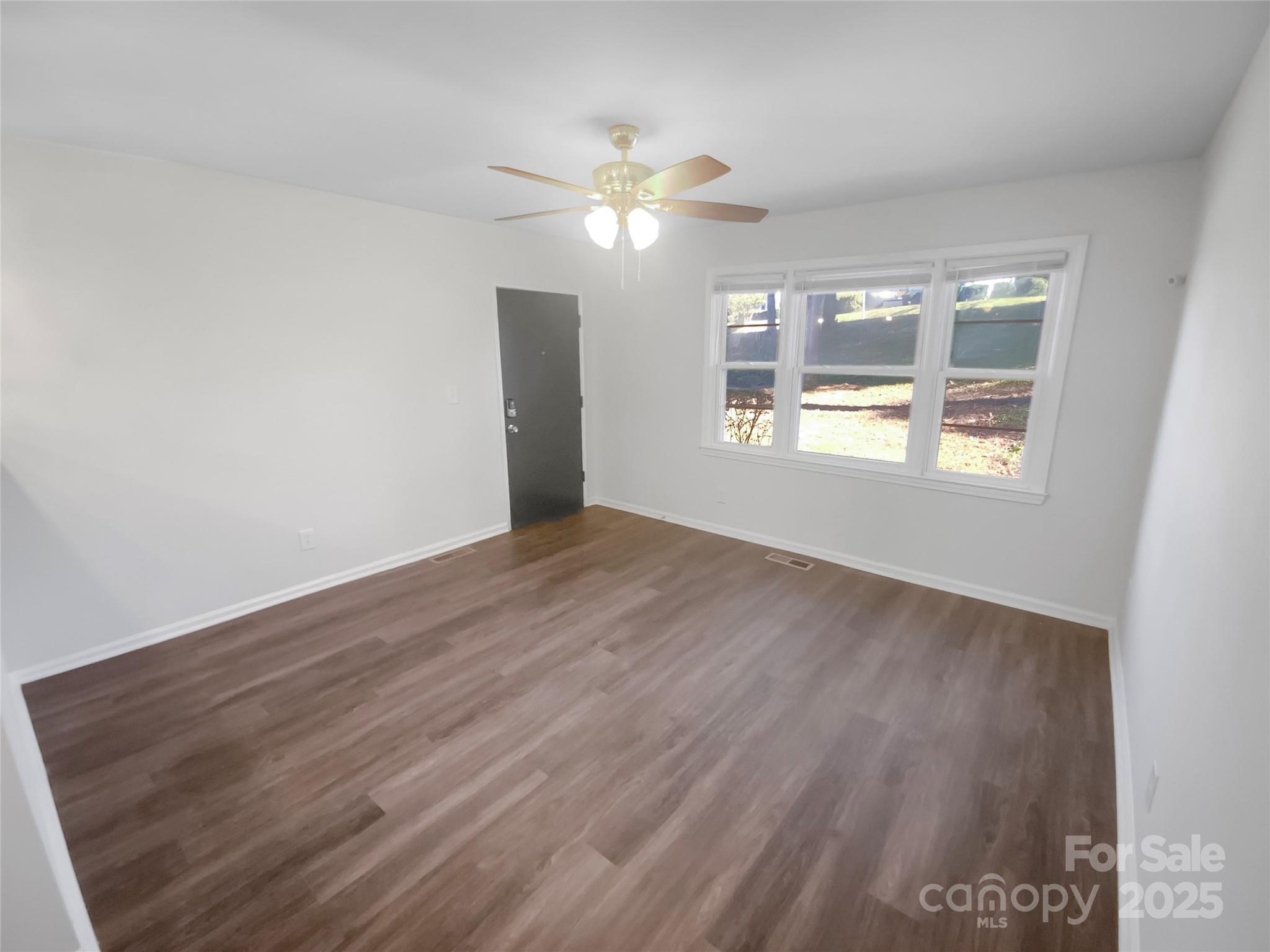 349 Wakefield Drive, Unit A Charlotte, NC 28209 - Photo 4 of 20 a view of an empty room with wooden floor and a window