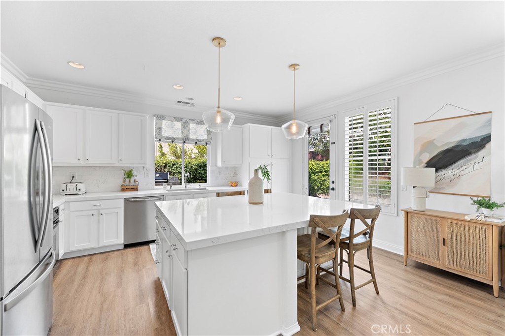 14 Celestine Circle Ladera Ranch, CA 92694 - Photo 13 of 42 a kitchen with stainless steel appliances kitchen island granite countertop a table chairs and a wooden floor