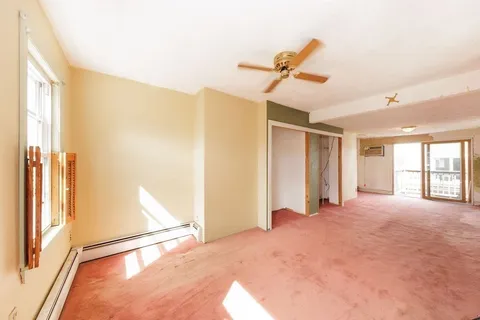 a view of a room with a ceiling fan and window