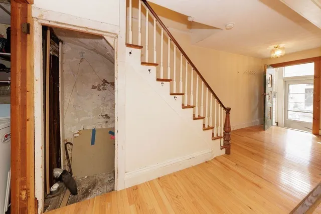 a view of a hallway with wooden floor and staircase