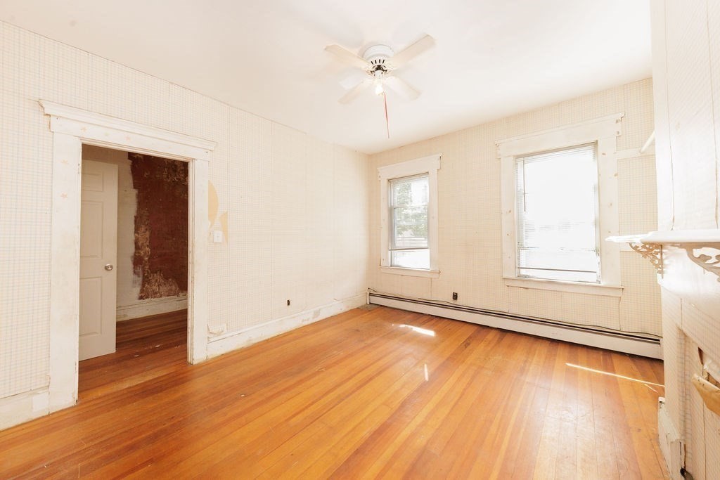 33 Russell Street Boston, MA 02129 - Photo 10 of 27 an empty room with wooden floor chandelier fan and windows