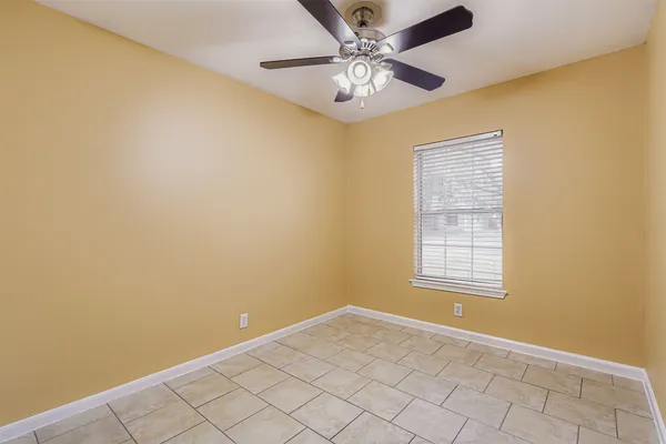 an empty room with windows and fan