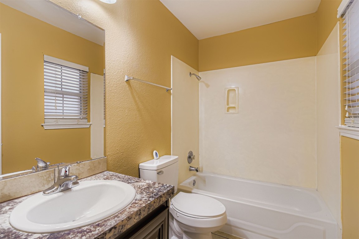 441 Keystone Loop Kyle, TX 78640 - Photo 15 of 17 a bathroom with a granite countertop sink toilet a mirror and shower