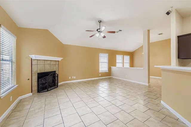 a view of an empty room with a fireplace and a window