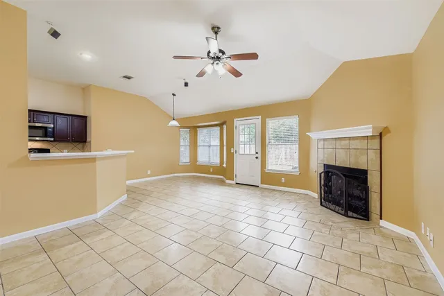 a view of an empty room with a fireplace and a window