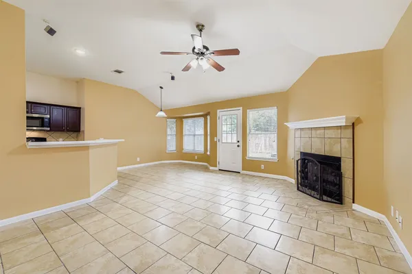 a view of an empty room with a fireplace and a window
