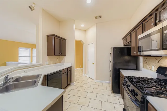 a kitchen with stainless steel appliances a stove a sink and a refrigerator