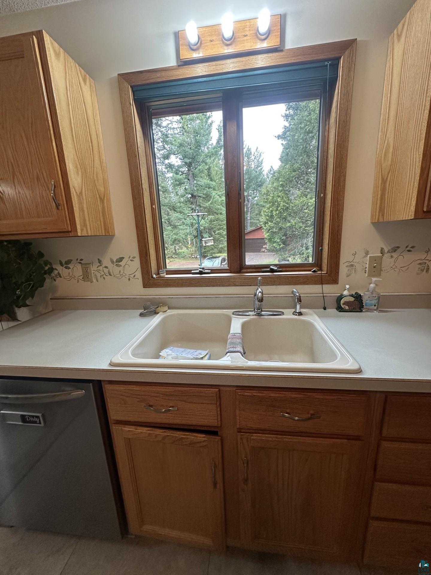 81 Hautaluoma Road Esko, MN 55733 - Photo 10 of 43 Kitchen sink area featuring a double basin, a window with natural wood trim, and overhead lighting