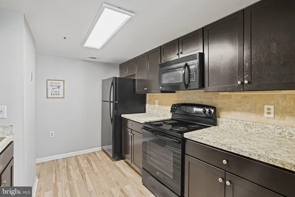 a kitchen with granite countertop stainless steel appliances a counter space and cabinets