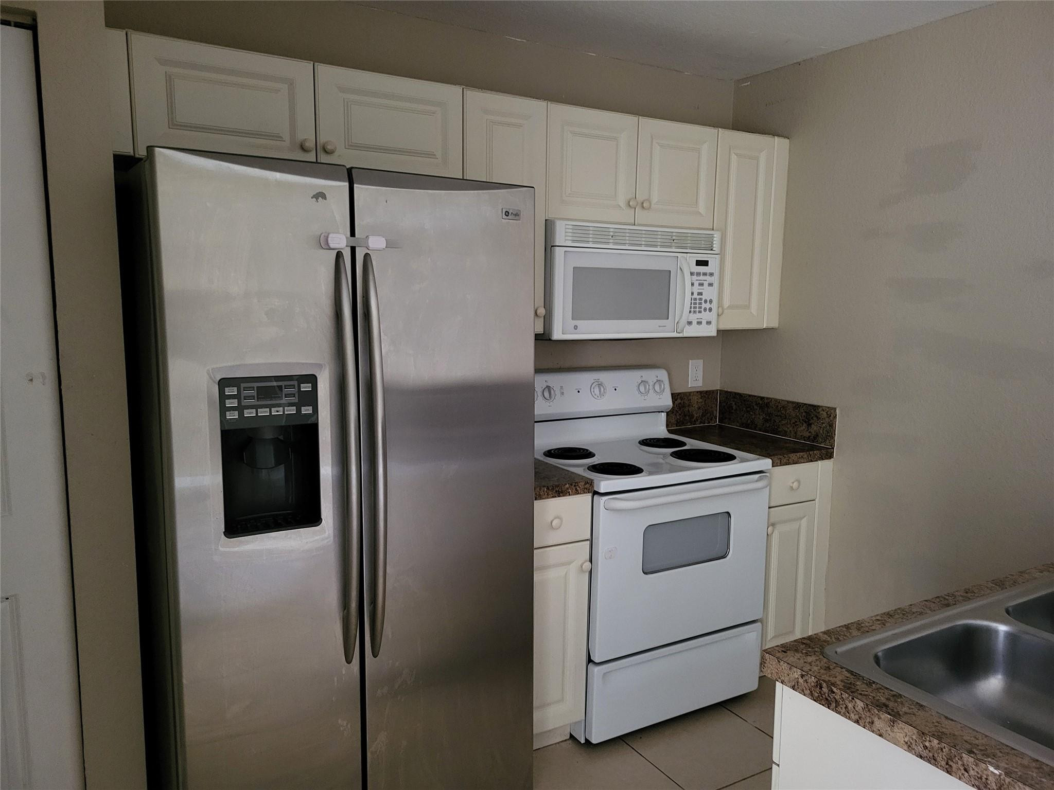 1957 Freeport Drive, Unit 1957 Riviera Beach, FL 33404 - Photo 5 of 14 a kitchen with a stove sink and refrigerator