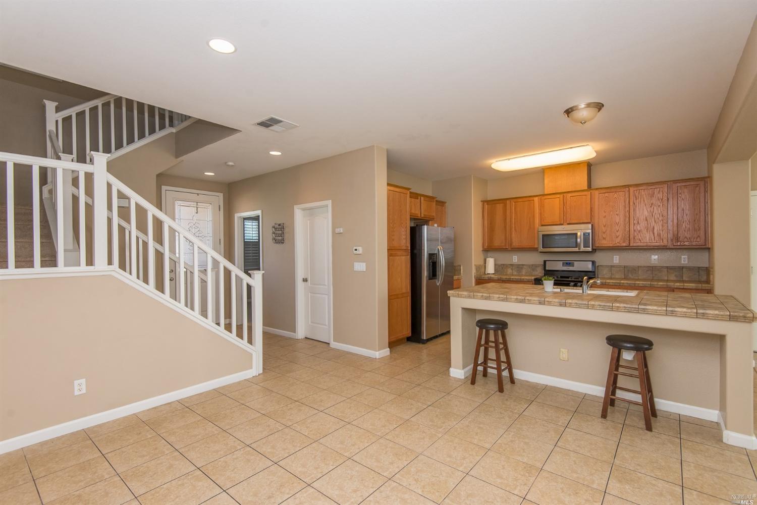 a open kitchen with stainless steel appliances granite countertop a refrigerator and a sink