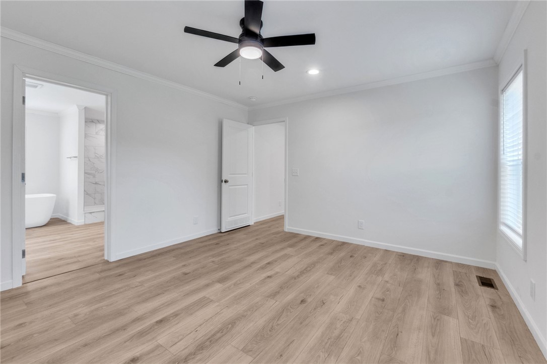108 Old River Road Iva, SC 29655 - Photo 11 of 31 A primary bedroom with light wood flooring and a modern ceiling fan, offering a seamless flow into the private bathroom.