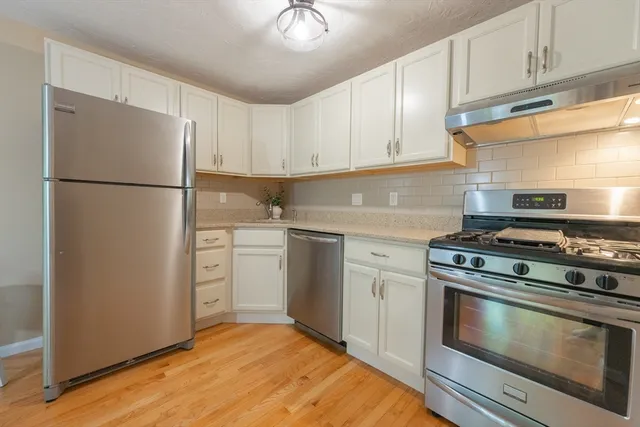 a kitchen with a refrigerator stove and white cabinets
