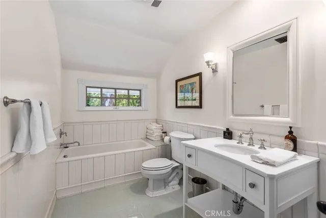 a bathroom with a toilet a sink a mirror and a bathtub