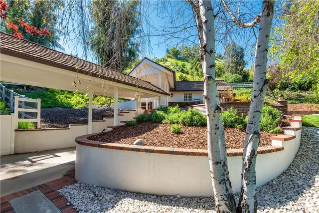 a view of a patio with couches plants and tree