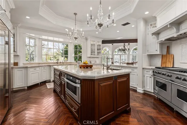 a kitchen with a sink stove and wooden floor