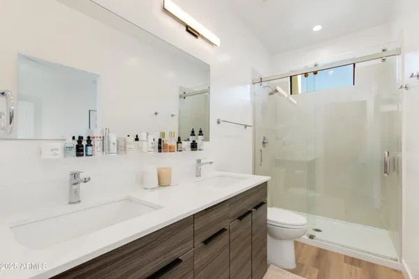 a bedroom with a bed and a flat tv screen on dresser