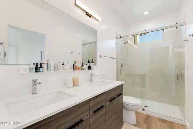 a bedroom with a bed and a flat tv screen on dresser