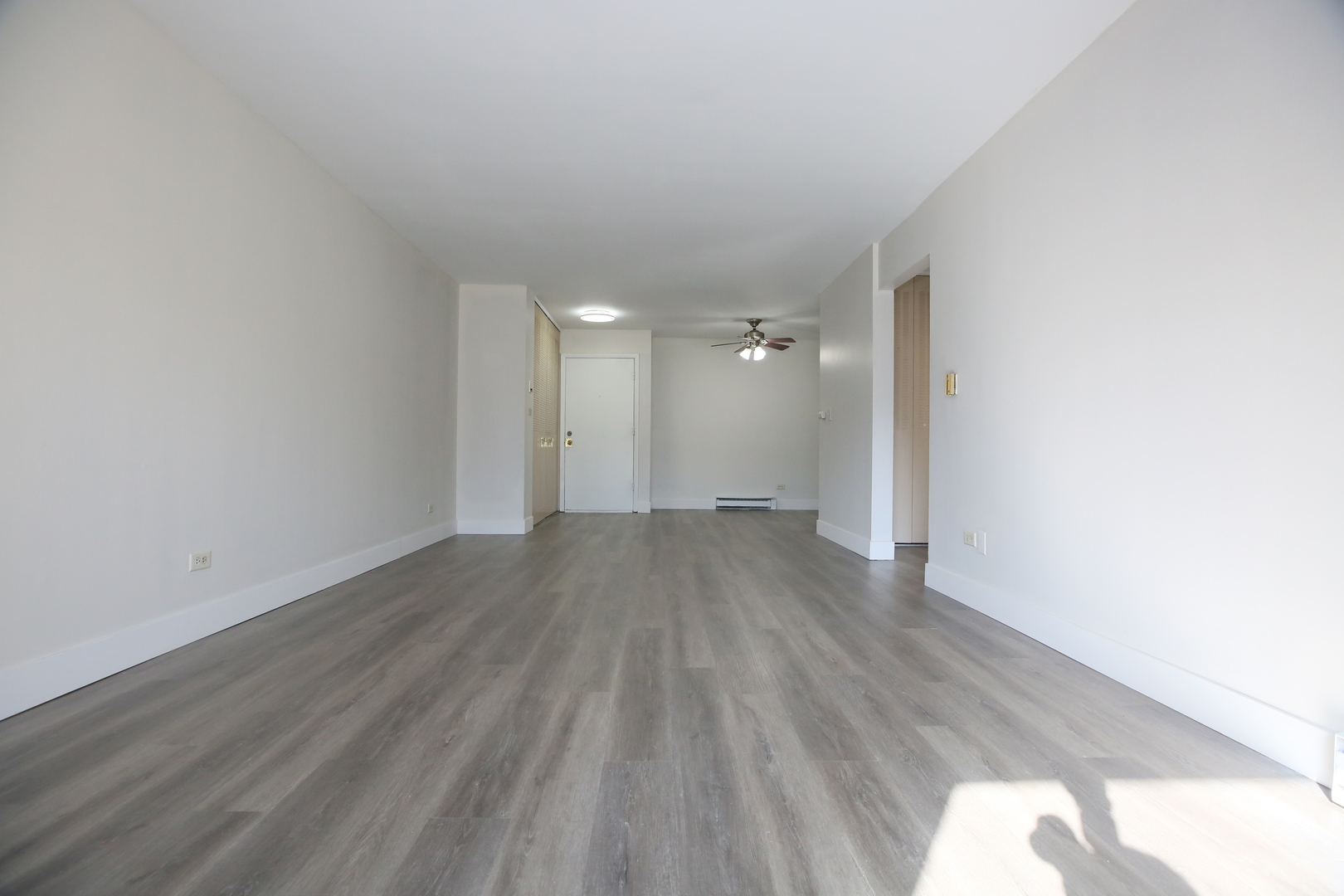 832 East Old Willow Road, Unit 105 Prospect Heights, IL 60070 - Photo 3 of 15 a view of a room with wooden floor and white walls