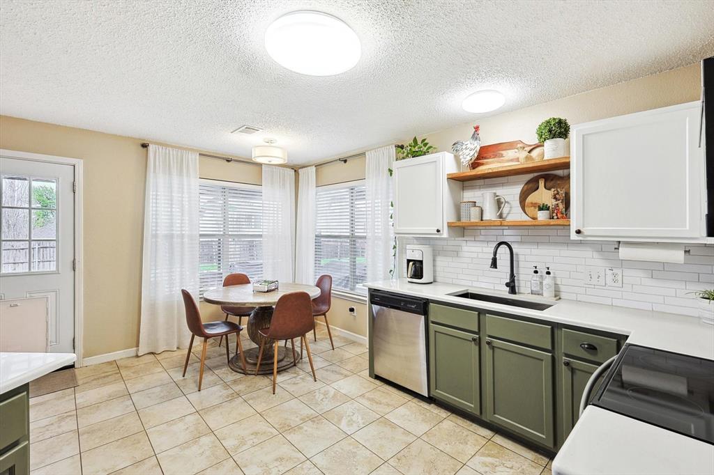 1016 Ridgetop Drive Justin, TX 76247 - Photo 13 of 40 Kitchen with green cabinetry, backsplash, a textured ceiling, light countertops, and dishwasher