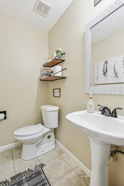 1016 Ridgetop Drive Justin, TX 76247 - Photo 14 of 40 Half bath featuring a textured ceiling and tile patterned floors