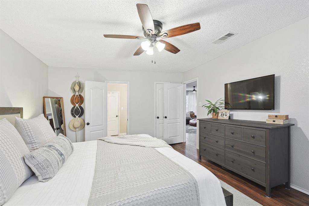 1016 Ridgetop Drive Justin, TX 76247 - Photo 16 of 40 Bedroom with dark wood finished floors, a textured ceiling, and a ceiling fan