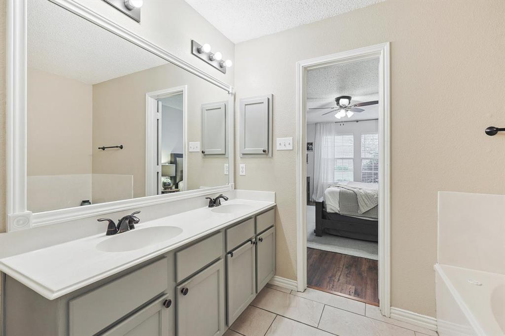 1016 Ridgetop Drive Justin, TX 76247 - Photo 19 of 40 Ensuite bathroom with a textured ceiling, double vanity, tile patterned floors, a tub, and ceiling fan