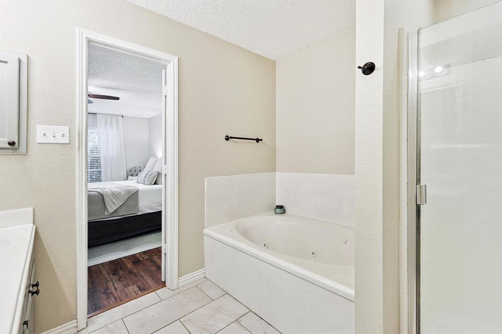 1016 Ridgetop Drive Justin, TX 76247 - Photo 20 of 40 Full bath featuring a textured ceiling, a jetted tub, ensuite bath, vanity, and a stall shower