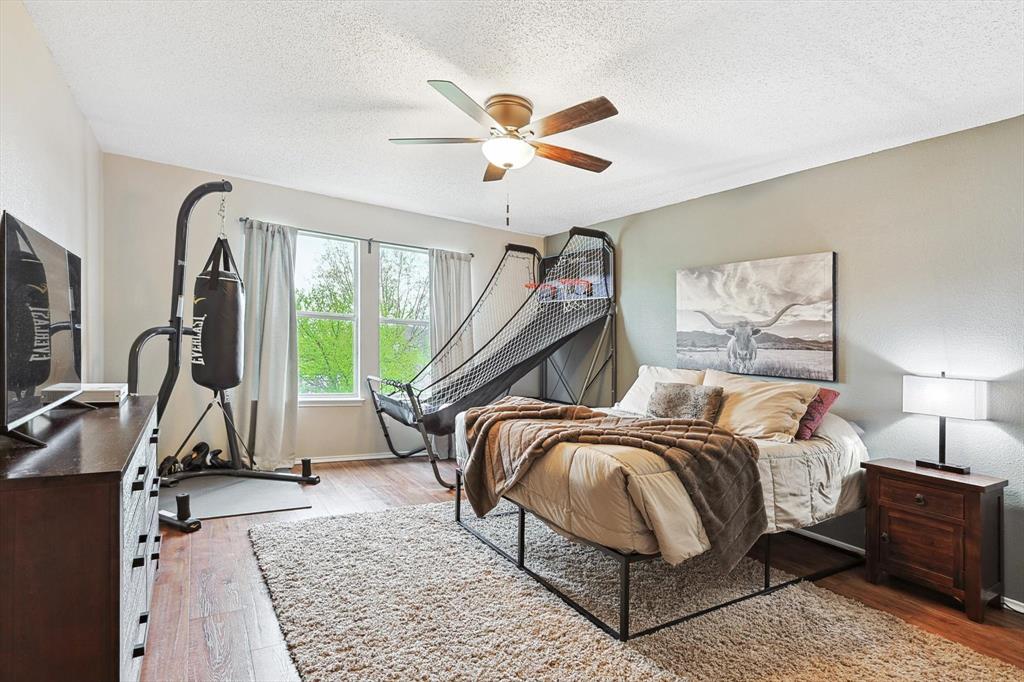 1016 Ridgetop Drive Justin, TX 76247 - Photo 25 of 40 Bedroom featuring wood finished floors, a textured ceiling, and ceiling fan